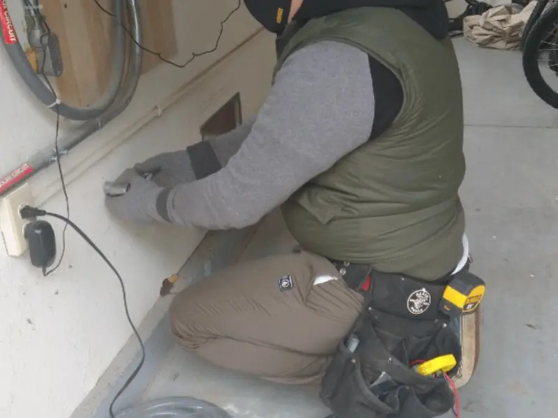 Electrician performing outlet wiring in a DeBary garage